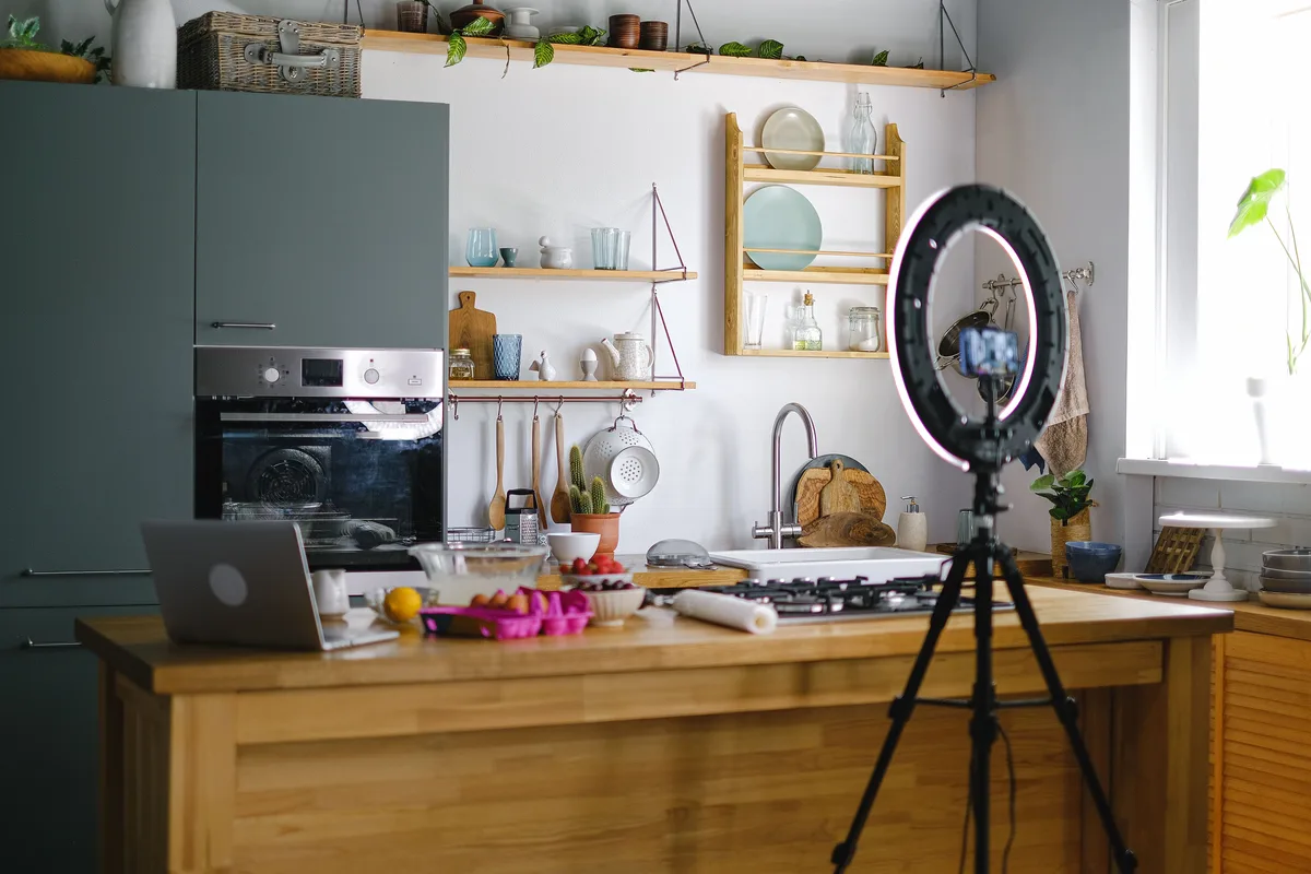 Ring light and tripod-mounted smartphone set up to record vertical video, a faceless creator&rsquo;s content setup