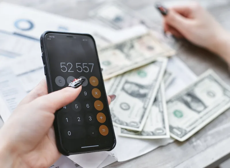 Close-up of hands using a budgeting app on a smartphone