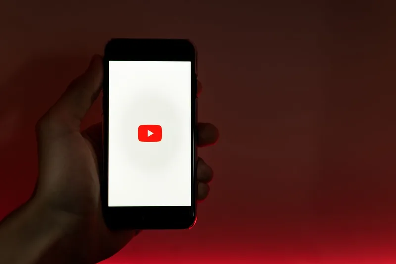 Hand holding a smartphone displaying a vertical video app