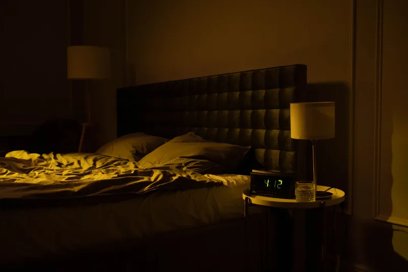 Dimly lit bedroom with a digital clock, representing sleep science content research