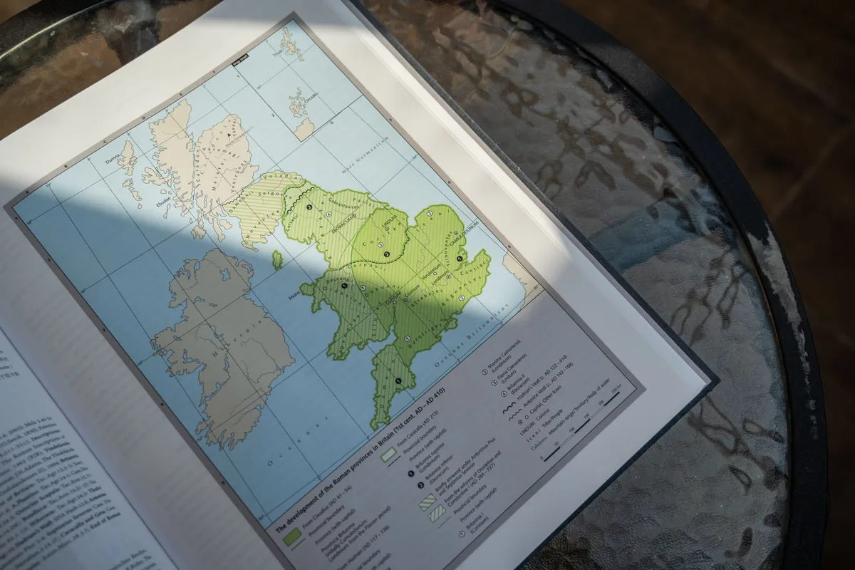 Open book showing a detailed map of Roman Britain on a table