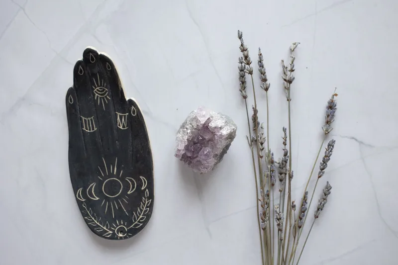 Crystals and dried herbs arranged on a table, part of the visual language in the spirituality-adjacent corner of the niche