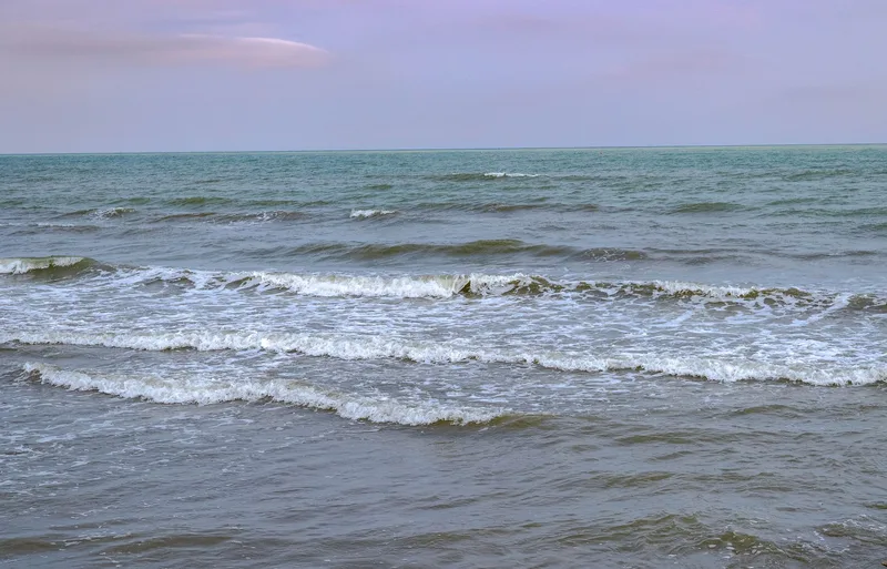Tranquil ocean waves under a pastel sunset sky, capturing nature’s soothing rhythm