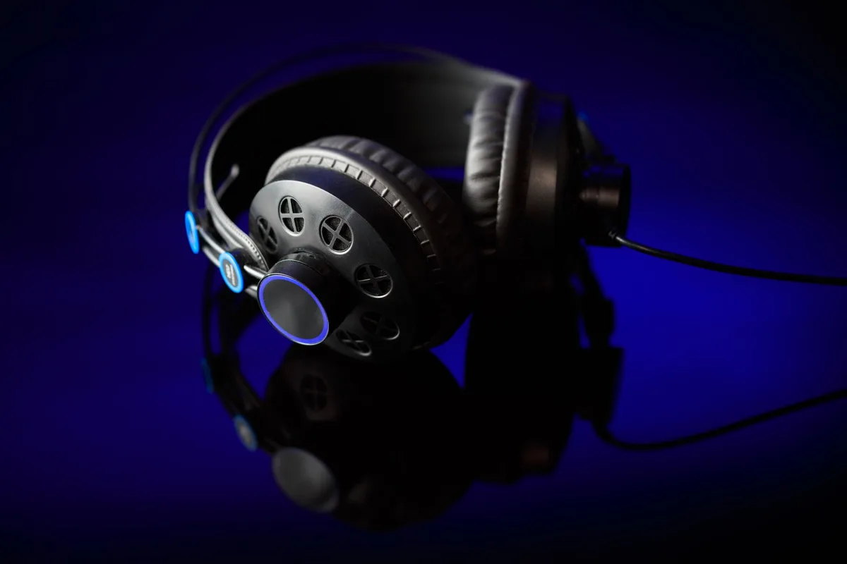 Stylish black headphones with glowing accents on a reflective surface against a dark backdrop