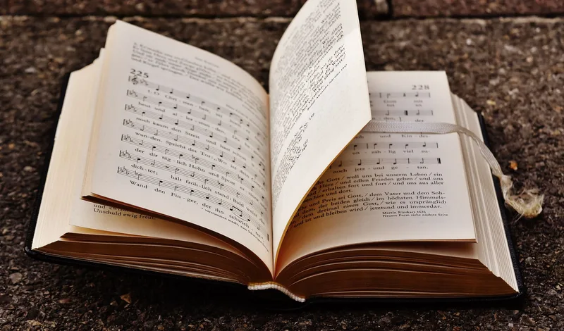 A close-up of an open antique book with aged, handwritten pages