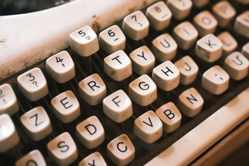 A close-up of vintage typewriter keys, representing the scripting work behind every episode