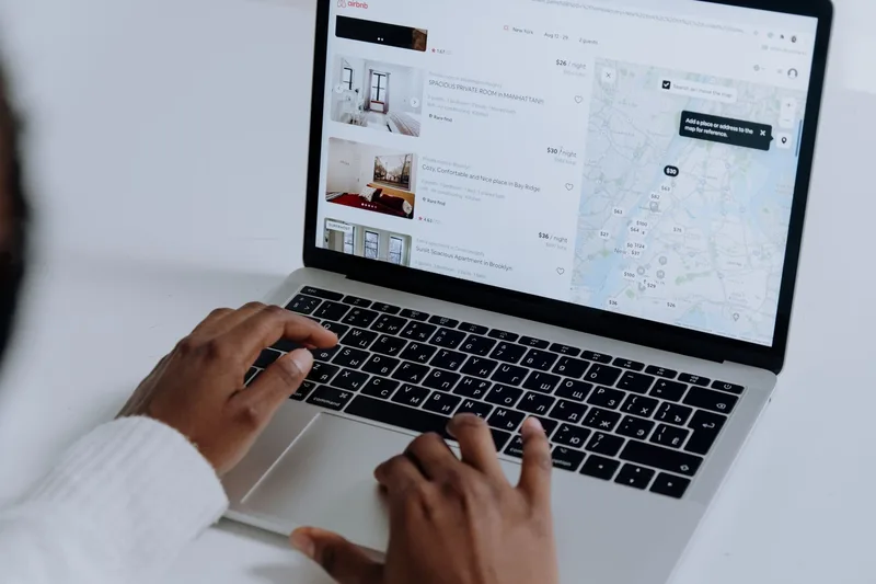 Laptop screen showing property listings and real estate market data charts