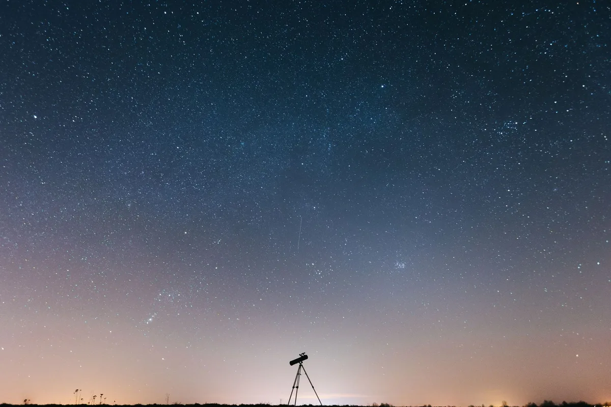 Stunning night sky filled with stars and a silhouette of a telescope
