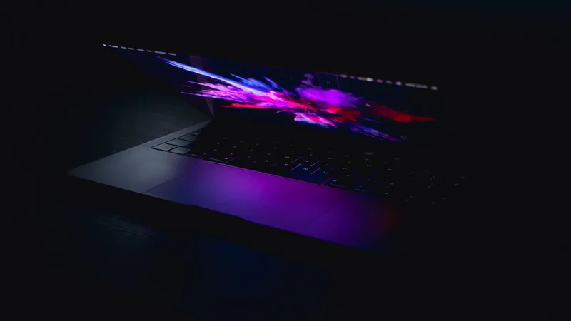 Laptop with glowing screen in low light representing the content upload and scheduling workflow