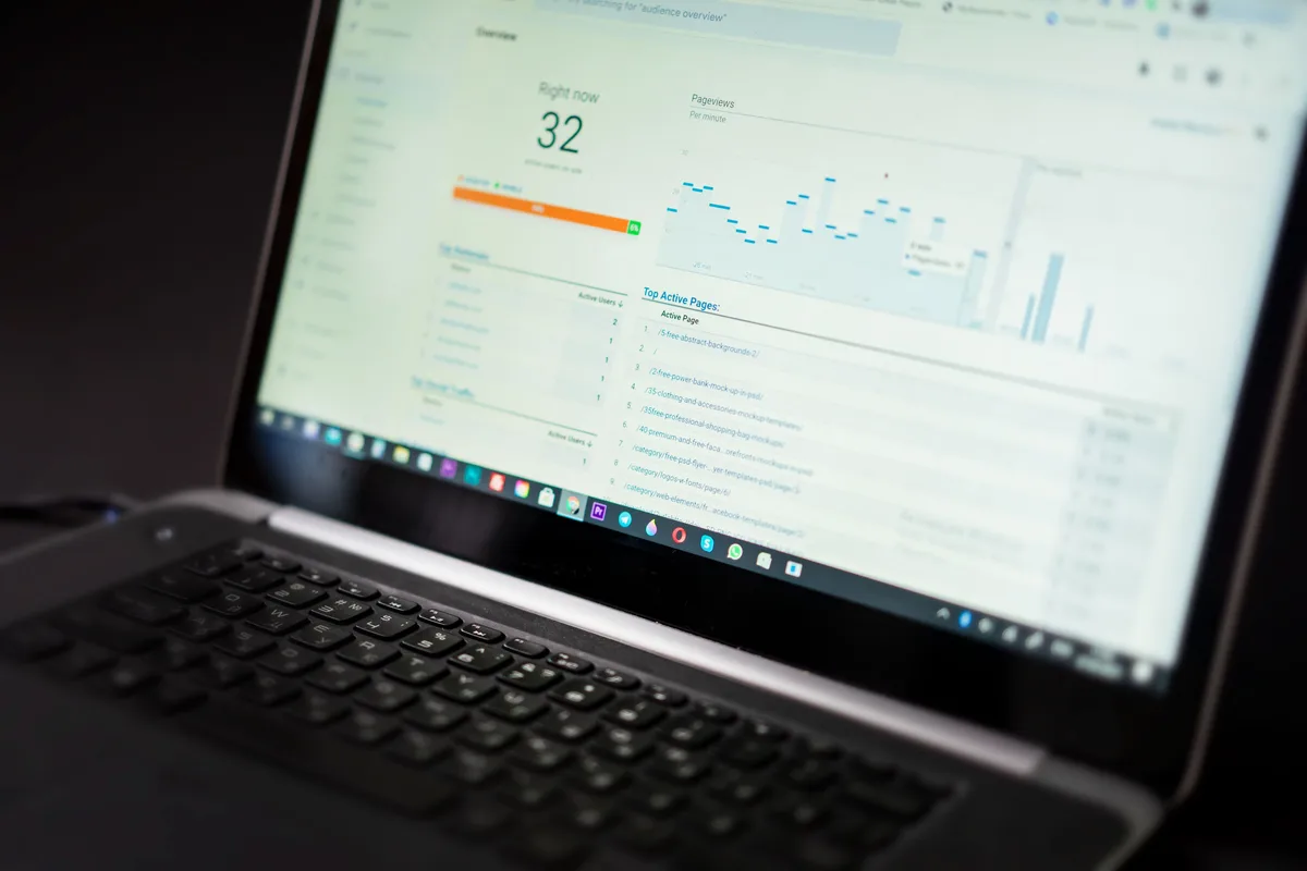 Dark analytics dashboard on a laptop screen showing real-time view counts and traffic charts, no person visible