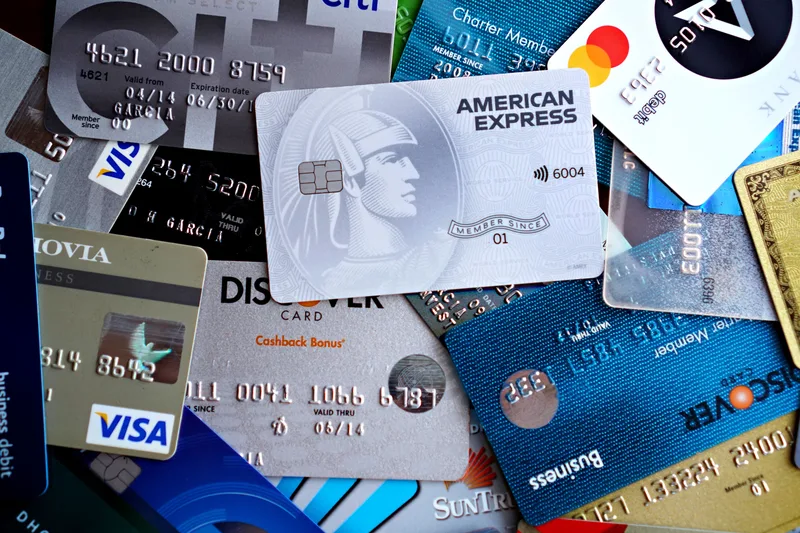 Stack of credit and debit cards on a dark background, representing subscription billing and credit-based pricing tiers