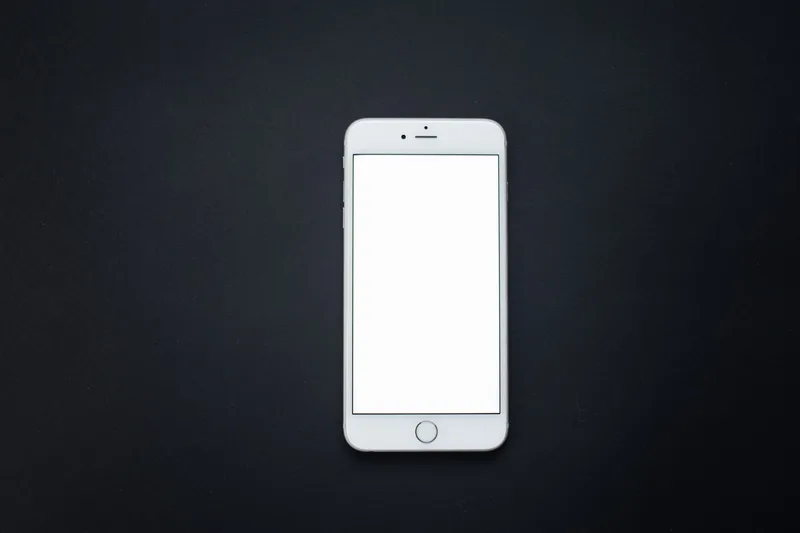 Smartphone with a blank white screen on a dark surface, representing vertical short-form video output for TikTok, Shorts, and Reels