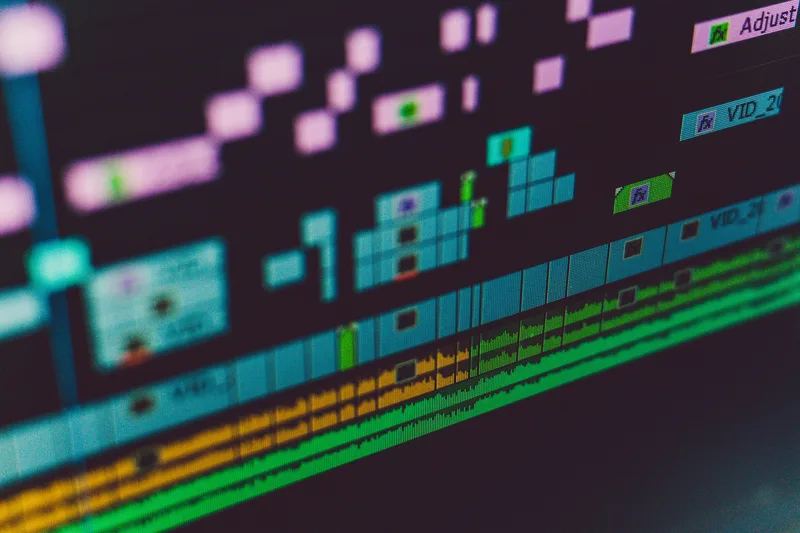 Dark video editing timeline interface with waveform and scene markers, representing automated text-to-video assembly