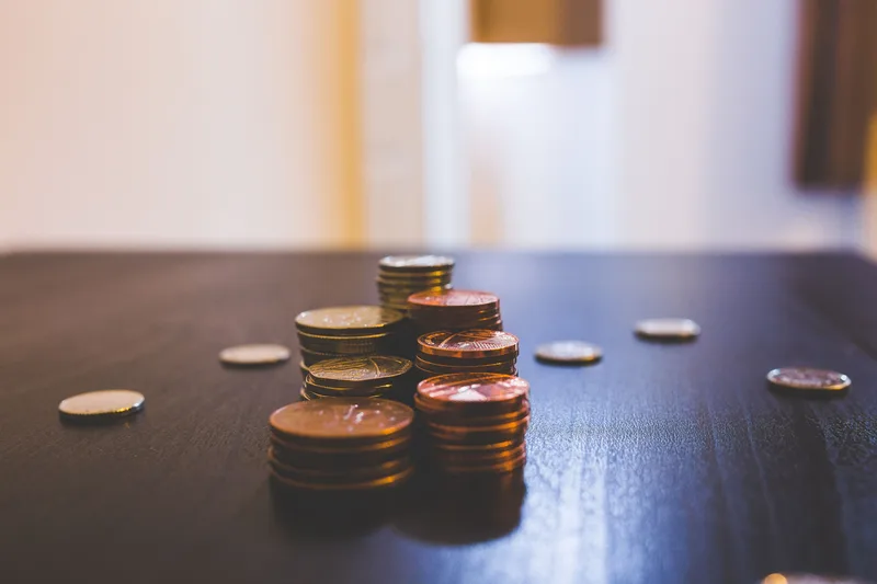 Small stacks of coins on a dark wooden table