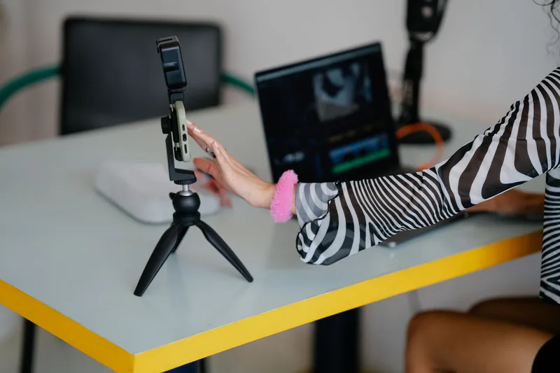 Woman with laptop and smartphone setup for content creation workflow