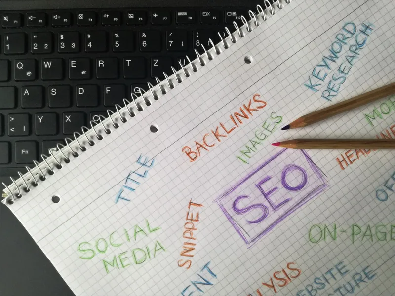 SEO keyword research notes and planning on paper next to a keyboard