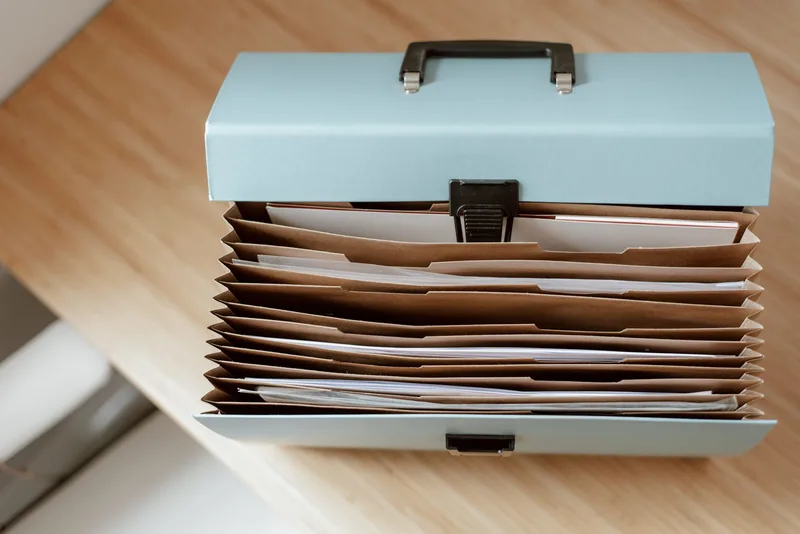Briefcase for documents with papers placed on a wooden table in daylight
