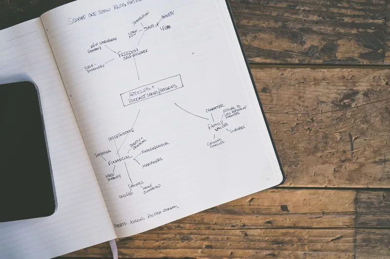 Notebook with a hand-drawn outline on a wooden desk, top view, no person visible