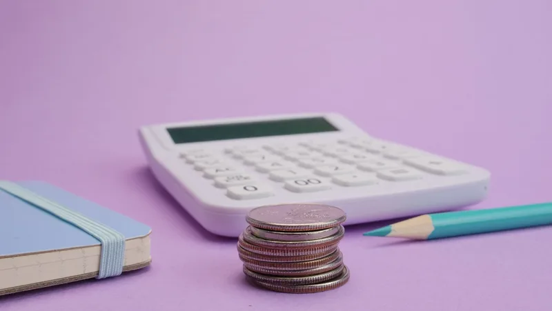 Calculator and coins on a desk representing subscription cost comparison